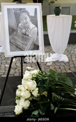 Dessau-Rosslau, Germania. Il 12 maggio 2017. Fiori prevista da una foto di Yangjie Li, un Cinese studente di architettura che è stata violentata e uccisa un anno fa, in corrispondenza di un evento commemorativo in Dessau-Rosslau, Germania, 12 maggio 2017. Foto: Peter Endig/dpa-Zentralbild/dpa/Alamy Live News Foto Stock