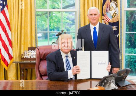 Stati Uniti Presidente Donald Trump visualizza il firmato un ordine esecutivo per la creazione di una Presidenza commissione consultiva sull elezione integrità come Vice Presidente Mike Pence guarda all Ufficio Ovale della Casa Bianca, 11 maggio 2017 a Washington, DC. Trump ha sostenuto, senza prove, che voto fraudolento costituisce un notevole e costante problema negli Stati Uniti e l'ordine crea una commissione di esaminare il problema. Foto Stock