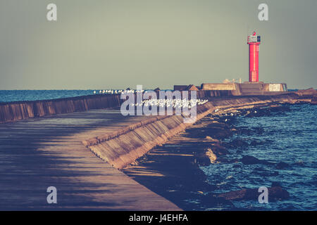 Faro rosso sul molo frangiflutti a Mar Baltico Foto Stock