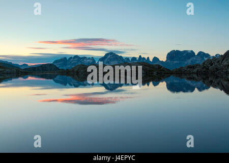 Cielo blu e nuvole rosa riflessa nel Lago Nero all'alba, Cornisello Pinzolo, Dolomiti di Brenta, Trentino Alto Adige, Italia Foto Stock