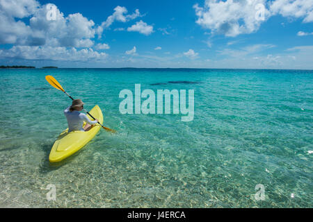 Donna kayak nelle acque turchesi di Tikehau, Tuamotus, Polinesia francese, Pacific Foto Stock