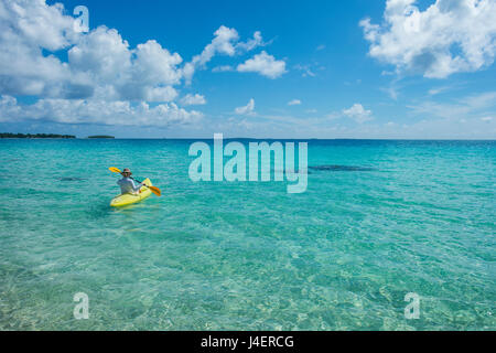 Donna kayak nelle acque turchesi di Tikehau, Tuamotus, Polinesia francese, Pacific Foto Stock