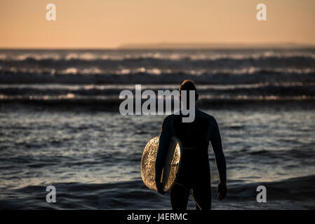 Un surfista contemplando le onde a Croyde Beach nel Devon, Inghilterra, Regno Unito, Europa Foto Stock