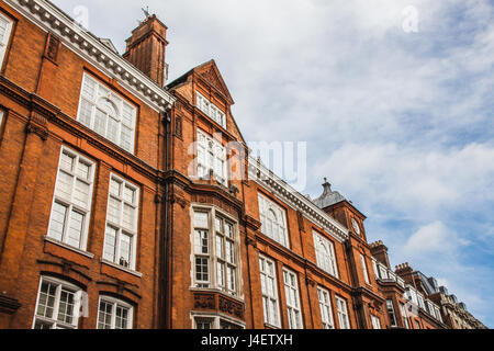 Old English case di mattoni a Londra, Regno Unito. Linea diagonale, composizione con cielo blu e nuvole. Foto Stock