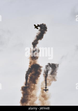 Silhouette di tre aerei su un display di acrobazia aerea. Gli aeroplani di disegno con fumi nell'aria. Foto Stock