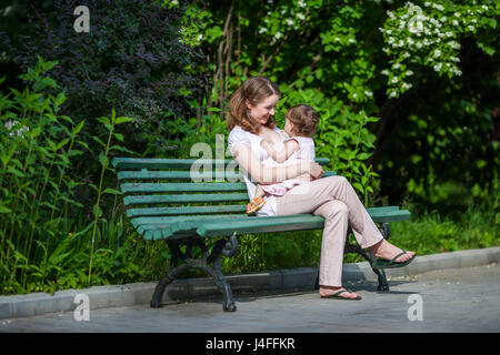 Madre felice di trascorrere del tempo con il toddler girl all'aperto Foto Stock