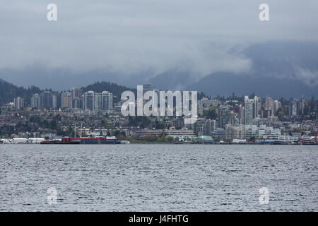 Un giorno a sopraggitto a Vancouver in Canada. Appendere le nuvole basse su edifici in North Vancouver. Foto Stock