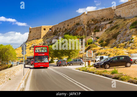 Rethymno, Grecia - 3 Maggio 2016: Red open double-decker bus panoramico Viaggiare sulla autostrada lungo la promenade Emmanouil Kefalogianni. La fortezza veneziana Foto Stock