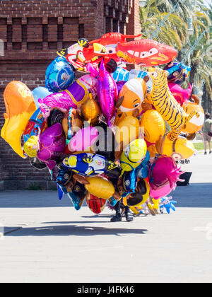 Un busker nascosti da palloncini colorati in vendita. Foto Stock