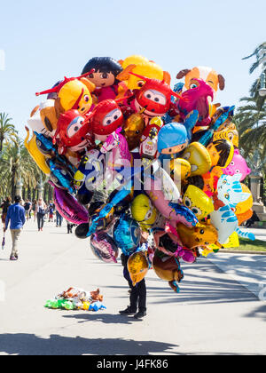 Un busker nascosti da palloncini colorati in vendita. Foto Stock