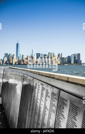 Nome di immigrati in pannelli di acciaio ad Ellis Island skyline di New York Foto Stock