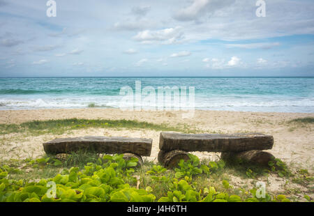 Due banchi solitario su una spiaggia alle Hawaii, con una splendida vista del verde smeraldo di onde in laminazione. Foto Stock