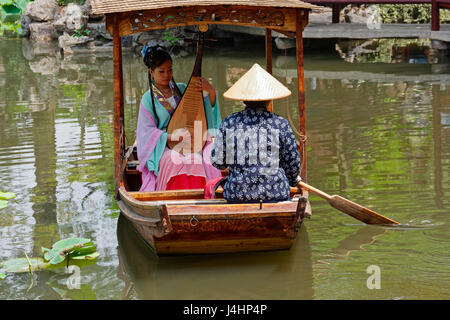 Due signore sedersi in una piccola imbarcazione, uno è la riproduzione di una pipa mentre uno è la remata, su un ampio laghetto in giardino dell umile amministratore.Ho Suzhou Foto Stock