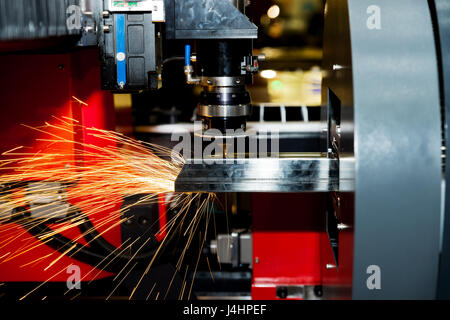 CNC taglio laser tubo metallico con un luminoso sparkle in fabbrica. L'industria della macchina. Foto Stock