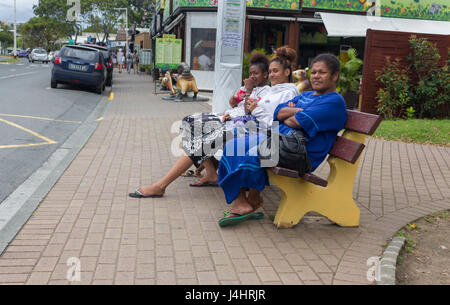 Noumea, Nuova Caledonia - febbraio 26th, 2017: tre nuovi caledonian donna seduta in attesa il bus di fronte al porto di Noumea. Foto Stock