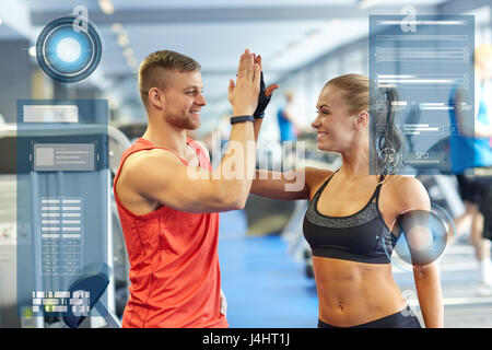 Uomo sorridente e la donna facendo alta cinque in palestra Foto Stock