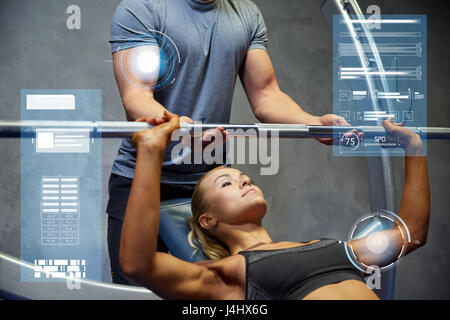 Uomo e donna con barbell flettendo i muscoli in palestra Foto Stock