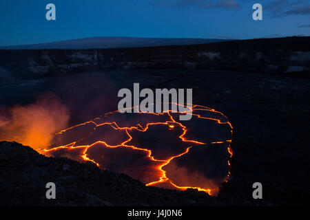 Il lago di lava di caldera Halemaumau di cratere del vulcano Kilauea, Hawaii, USA, con il Mauna Loa mountain in background in pre-alba Foto Stock