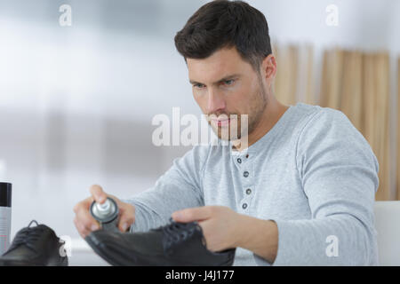 L'uomo pulisce la sua scarpe scamosciate Foto Stock