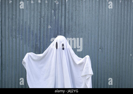 Un fantasma bianco di fronte a una porta di garage Foto Stock