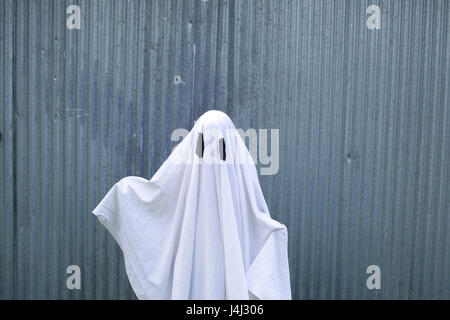 Un fantasma bianco di fronte a una porta di garage Foto Stock