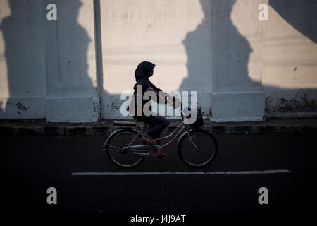 Una donna musulmana in sella a una moto in Yogyakarta, Java, Indonesia. Foto Stock