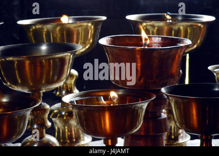Primo piano della Buddista Tibetana rituale olio lampada candela monastero buddista. Foto Stock