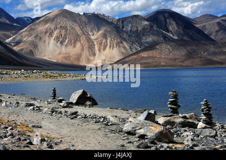 Alte montagne del Lago Pangong: blu di superficie di acqua marrone, montagne, in primo piano una strada di campagna e piccolo stupa buddisti, Ladakh, indi settentrionale Foto Stock