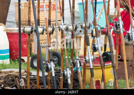 Una fila di vecchi pali di pesca si appoggia pigramente in un prato vendita. Foto Stock