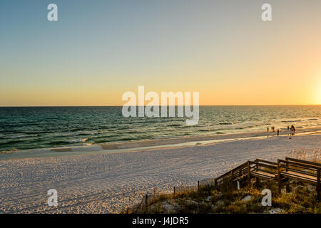 La gente camminare su una costa del Golfo della Florida spiaggia vicino Destin, in Florida, Stati Uniti d'America, al tramonto. Foto Stock