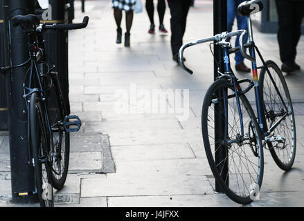 Due biciclette incatenati a firmare messaggi Foto Stock