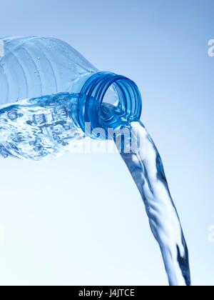 Pouring water from a plastic bottle, studio shot. Foto Stock