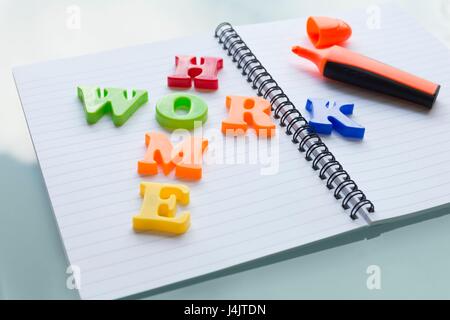Lettere colorate sul notebook compiti di ortografia. Foto Stock