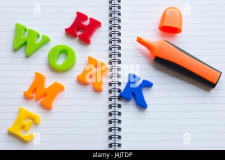 Lettere colorate sul notebook compiti di ortografia. Foto Stock