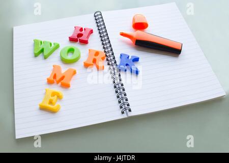 Lettere colorate sul notebook compiti di ortografia. Foto Stock