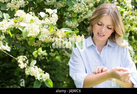 Giovane donna di albero braccio di graffiatura. Foto Stock