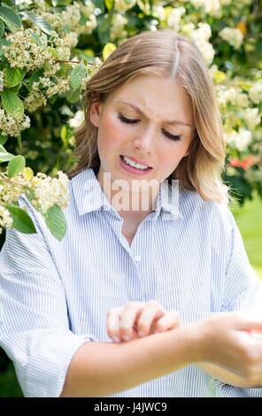 Giovane donna di albero braccio di graffiatura. Foto Stock