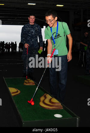 161001-N-VH385-006 OCEANO ATLANTICO (ott. 1, 2016) Petty Officer 1. Classe Kevin Karnes, da San Jose, California, gioca a mini-golf con suo figlio nella baia di hangar della portaerei USS George Washington (CVN 73). George Washington è homeported in Norfolk dopo aver servito per sette anni a Yokosuka, Giappone, come negli Stati Uniti La marina è solo distribuita portaerei. (U.s. Navy foto di Sottufficiali di terza classe Wyatt L. Anthony) Foto Stock