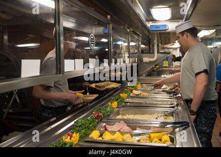 161002-N-BR087-081 OCEANO PACIFICO (ott. 2, 2016) Il Marinaio Jacob Flores, da Rockport, Texas, serve il brunch marinai da USS John C. Stennis' (CVN 74) cucina a poppa. John C. Stennis è in corso conducendo le competenze e il supporto della formazione. (U.S. Foto di Marina con marinaio Cole C. Pielop / rilasciato) Foto Stock