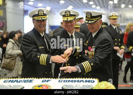 170109-N-YG104-010 Sasebo, Giappone (GEN. 9, 2017) posteriori Adm. Marc H. Dalton, comandante della Forza anfibia flotta 7, cap. George Doyon, comandante di squadrone anfibio (PHIBRON) 11, e il cap. Ed Thompson, comandante uscente della PHIBRON-11, unirsi insieme per una torta cerimoniale taglio durante un cambiamento di cerimonia di comando a bordo dell'assalto anfibio nave USS Bonhomme Richard (LHD 6). Doyon alleviato Thompson come comandante di PHIBRON-11 durante la cerimonia. (U.S. Foto di Marina di Massa lo specialista di comunicazione 2a classe Sarah Villegas/rilasciato) Foto Stock