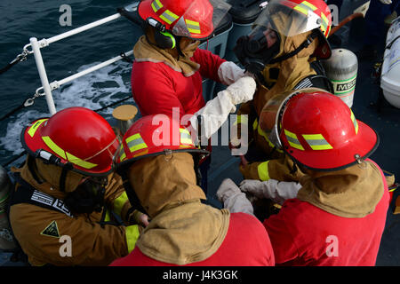 Il suo equipaggio a bordo del guardacoste Pesce spada assistono reciprocamente mediante il serraggio di lotta antincendio marcia mentre in corso vicino a Port Angeles, nello Stato di Washington, 6 febbraio 2017. Il 87-Protezione piedi pattuglia di classe equipaggio restituiti alla porta dopo la nave ha registrato una fuoriuscita di olio nella camera del motore. Stati Uniti Coast Guard foto di Sottufficiali di seconda classe Flockerzi Ali. Foto Stock