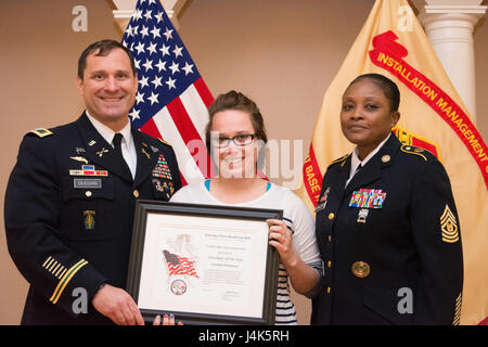 Base comune sala Myer-Henderson Commander Patrick M. Duggan e il comando Sgt. Il Mag. Carolyn Y. Donaldson presente la signora Lori Thompson con un volontario del premio di anno Aprile 16, 2017 in Spates Hall sulla JBM-HH, Va. Thompson ha continuato a Excel di aiuto ai soldati, famiglie e comunità in quanto provenienti per il post. (U.S. Esercito foto di Spc. Daniel Yeadon) Foto Stock