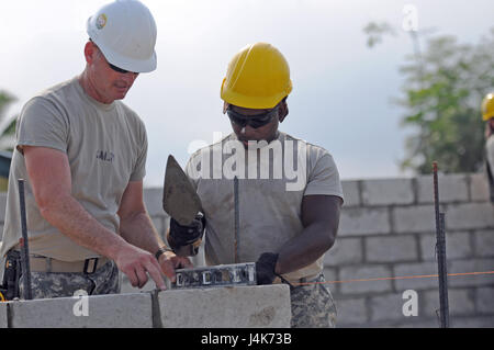 Sgt. 1. Classe James Salm, progetto noncommissioned officer in carica per il San Matteo di governo scuola cantiere, spiega i punti più delicati di posa cinderblock a Spc. Jacari Williams, un meccanico HVAC cross-training durante oltre l'orizzonte 2017, 1 Maggio, San Matteo Belize. Entrambi i soldati riservisti sono con l'Ingegnere 372 Società, fuori di Pewaukee, Wisconsin. BTH è un U.S. Comando sud-sponsorizzato, esercito sud-led esercizio progettata per fornire aiuti umanitari e i servizi di ingegneria per le comunità nel bisogno, dimostrando il supporto degli Stati Uniti per il Belize. Foto Stock