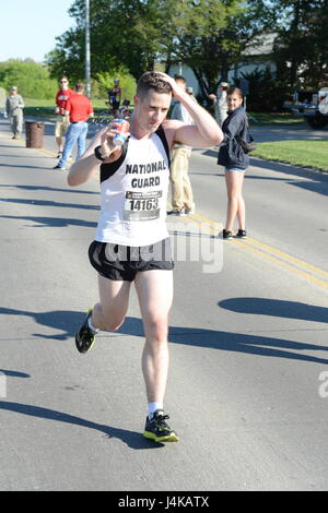 Protezione superiore Runner: 1Lt. Kenneth Rayneri, comandante del distretto di Columbia esercito Guardia nazionale presso la sede centrale e la sede di distacco, 74a comando di truppa, versa acqua su se stesso di rimanere fresco mentre si avvicina il punto mediano del Lincoln Guardia Nazionale Maratona in Lincoln, Neb., su un caldo Maggio 7 giorno. Rayneri ha vinto la Guardia Nazionale maschio del titolo di divisione con un tempo di 2 ore, 42 minuti e 47 secondi. (Nebraska Guardia Nazionale foto di Capt. Alex salmone) Foto Stock