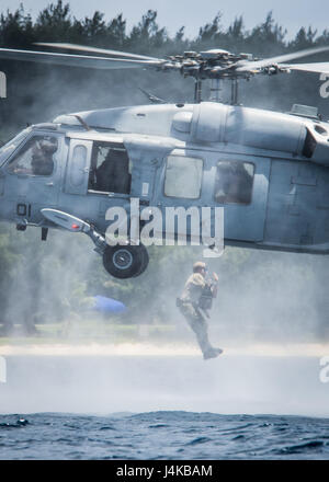 Un marinaio assegnato per l'eliminazione degli ordigni esplosivi unità mobile 5 (EODMU5) plotone 142 esce un MH-60 Seahawk appartenenti alla "Isola Cavalieri del Mare in elicottero Combat Squadron 25 (HSC-25) al largo di Guam Maggio 8, 2017. EODMU5 sta attualmente testando la sua capacità di distribuire beni da varie piattaforme, compresi gli elicotteri e pattuglie, ad aumentare la sua interoperabilità adattativo. EODMU5 conduce la mia contromisure, esplosivi improvvisati operazioni del dispositivo, rende sicuro rischi di esplosione e disarma underwater esplosivi come mine. (U.S. Navy combattere la foto della telecamera tramite la comunicazione di massa Speciali Foto Stock