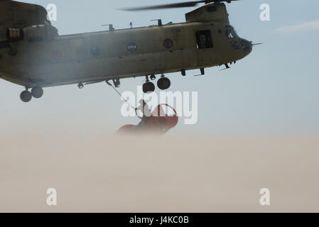 Sgt. 1. Classe Chris Richards del Connecticut Guardia nazionale attribuisce a 12.000-pound spiaggiata boa per un CH-47 elicottero Chinook, Martedì, 9 maggio 2017, vicino a Chatham, nel Massachusetts. Il Chinook sollevato la boa dalla spiaggia e lo portò in mare aperto dove Guardacoste Oak ritirato. (U.S. Coast Guard foto di Sottufficiali di terza classe Andrew Barresi) Foto Stock