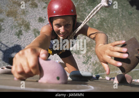 Barre di parete, donna, sorriso, salire dal di sopra al di fuori, estate, giardino d'arrampicata, arrampicata allegato, tempo libero, lifestyle, hobby, alpinista, giovani, sport, arrampicata sportiva, sportily, ceppo, perseveranza, forza, corda, backup, casco, impugnature di arrampicata, felicemente, allegria e divertimento Foto Stock