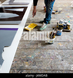 Artista caucasica pittura con rullo di vernice Foto Stock