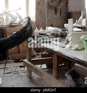 Artista caucasica rilassante con i piedi sul tavolo Foto Stock