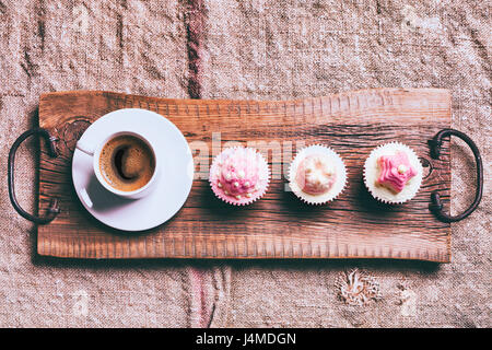 Caffè e tortine sul vassoio in legno Foto Stock